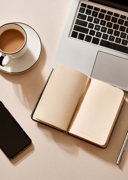 A notebook, coffee and laptop ready for an SEO session